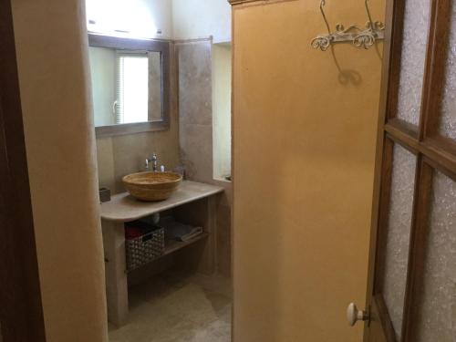 une salle de bain avec un lavabo et un miroir dans l'établissement typical provencal bastide, built of local stones, in the luberon in cheval-blanc with secured pool and wifi -sleeps 6 people., à Cheval-Blanc