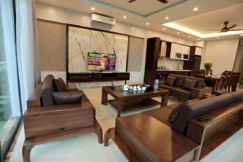a living room with a couch and a tv at Flamigo Dai Lai Resort - Happy Villa in Ngọc Quang