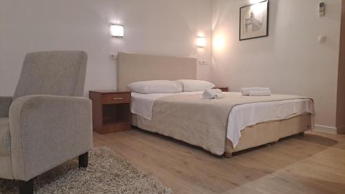 a bedroom with a bed and a chair at Medulić Palace Rooms & Apartments 2 in Šibenik