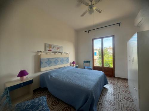 a bedroom with a blue bed and a window at Sa domo manna in Porto Ottiolu