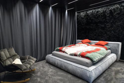 a bedroom with a bed and a chair at BÚDA Jasná in Demanovska Dolina