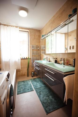 a bathroom with a sink and a tub and a window at Charmantes Haus -Nähe Parndorf-Neusiedl-Wien-HU-SK in Bruck an der Leitha