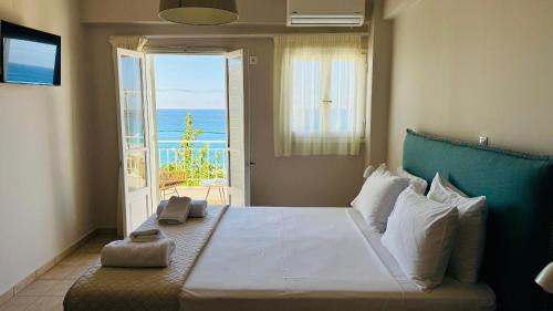 a bedroom with a bed with a view of the ocean at Monato Luxury Apartments in Agios Nikitas