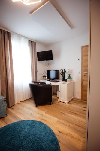 a living room with a desk and a chair at Charmantes Haus -Nähe Parndorf-Neusiedl-Wien-HU-SK in Bruck an der Leitha