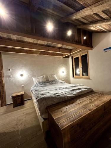 une chambre avec un lit dans une pièce avec des plafonds en bois dans l'établissement Le Charlet Versaille, à Passy