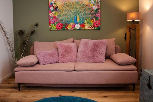 a couch with pink pillows in a living room at Charmantes Haus -Nähe Parndorf-Neusiedl-Wien-HU-SK in Bruck an der Leitha