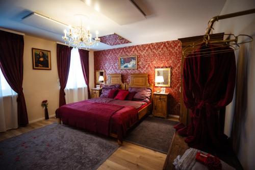 a bedroom with a bed with red walls and a chandelier at Charmantes Haus -Nähe Parndorf-Neusiedl-Wien-HU-SK in Bruck an der Leitha
