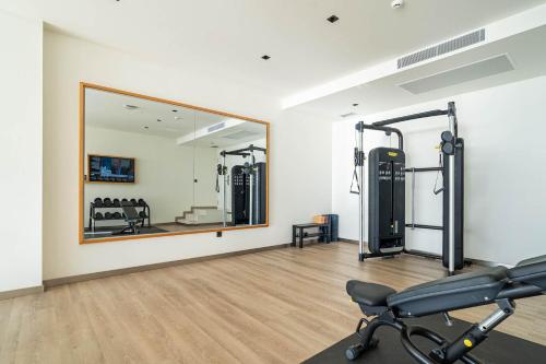 a gym with a mirror and a chair in a room at Royal Marina Suites Boutique Hotel - Adults Only in Puerto Calero