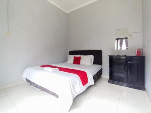Un dormitorio con una cama y una cómoda. en RedDoorz at Penginapan Hello Pacitan, en Pacitan