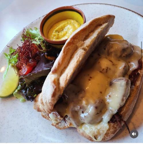 a plate of food with a sandwich with meat and sauce at Jacques van Marken Erfgoed in Delft