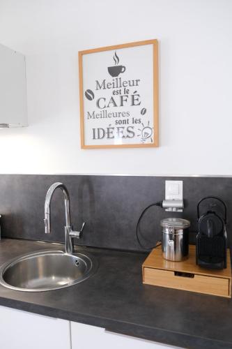 un comptoir de cuisine avec un évier et un tableau sur le mur dans l'établissement very pleasant house with swimming pool in mouriès, near Les baux de provence in the alpilles – 6 people, à Mouriès