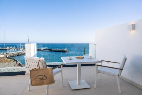 a table and chairs on a balcony with a view of the ocean at Royal Marina Suites Boutique Hotel - Adults Only in Puerto Calero