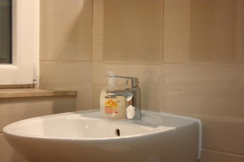 a white sink with a bottle of soap on it at Medulić Palace Rooms & Apartments 2 in Šibenik