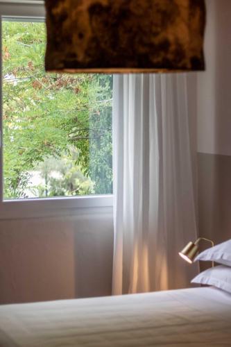 a bedroom with a window with a white curtain at Lu. b&b in Cervia