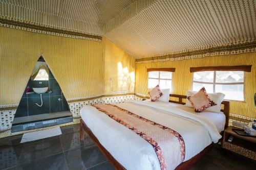 a large bed in a room with yellow walls at RiverView Tent Resort in Kevadia