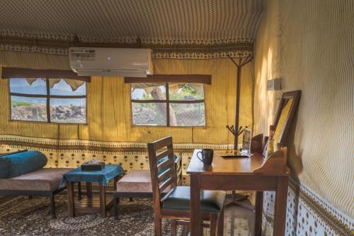 a room with a desk and a table and chairs at RiverView Tent Resort in Kevadia