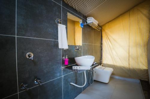a bathroom with a sink and a toilet at RiverView Tent Resort in Kevadia