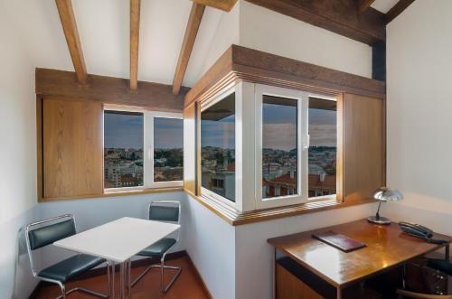 an office with a table and chairs and windows at Hotel Principe Real in Lisbon