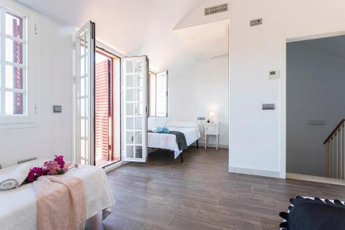 a white room with two beds and a mirror at 5 Rooms 5 baños Acceso Playa Free Parking in Cádiz