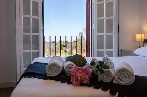 a bedroom with a bed with towels and a window at 5 Rooms 5 baños Acceso Playa Free Parking in Cádiz