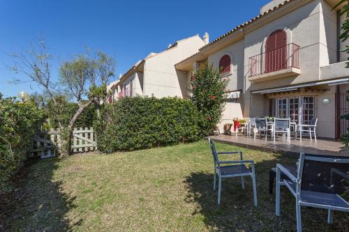 a yard with chairs and a table in front of a house at 5 Rooms 5 baños Acceso Playa Free Parking in Cádiz
