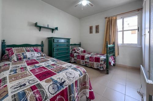 a bedroom with two beds and a window at R2308 La Medina Vera Playa Almería in Los Amarguillos