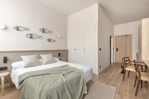 a bedroom with a bed and a table and chairs at Líbere Málaga Trinidad in Málaga