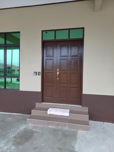 瓜拉丁加奴MAA Roomstay B的建筑物前有垫子的门