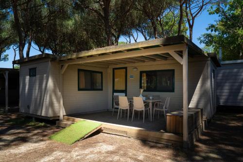 a small house with a table and chairs on a deck at Club del Sole Adriano Family Collection in Punta Marina