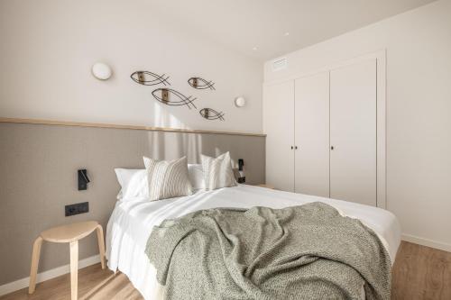 a bedroom with a white bed with a blanket on it at Líbere Málaga Trinidad in Málaga