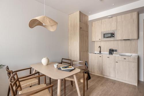 a kitchen and dining room with a table and chairs at Líbere Málaga Trinidad in Málaga