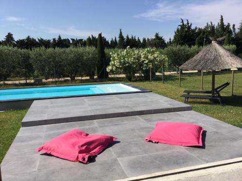two pink towels sitting on a table next to a swimming pool at beautiful provencal mas with pool in barbentane, close to avignon, sleeps 8. in Barbentane