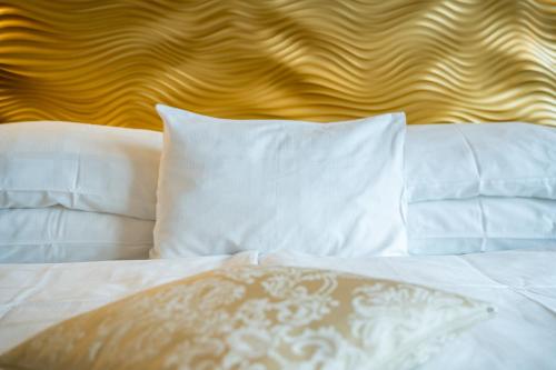 a white bed with white pillows and a wooden headboard at Hotel Josefshof am Rathaus in Vienna