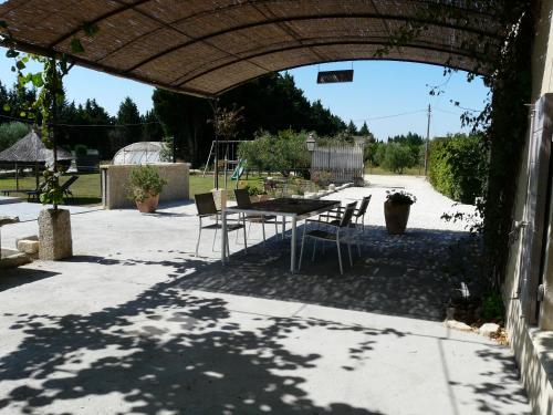 a patio with a table and chairs under an archway at beautiful provencal mas with pool in barbentane, close to avignon, sleeps 8. in Barbentane