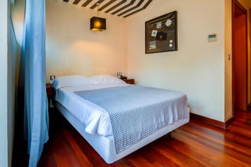 a bedroom with a white bed with a blue blanket at Hotel Principe Real in Lisbon