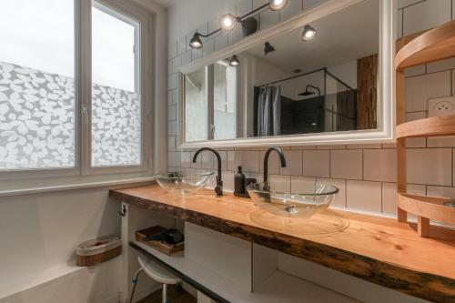 ein Badezimmer mit zwei Waschbecken und einem Spiegel in der Unterkunft Maison jacuzzi-sauna Station 7 Laux in Theys