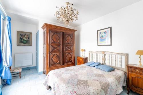 une chambre avec un lit et un lustre dans l'établissement Propriété historique La Joséphine 1828, à La Barre-de-Monts