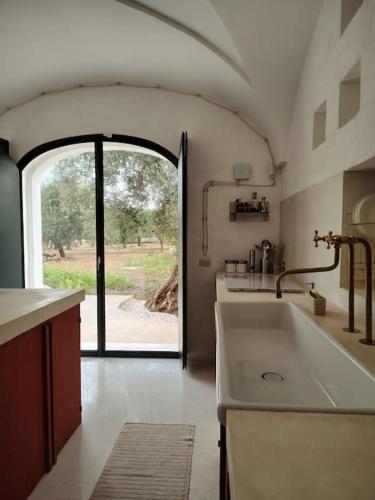 a kitchen with a large sink and an open door at Casa Lama in Monopoli