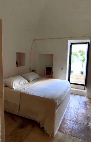 a white bed in a bedroom with a window at Casa Lama in Monopoli