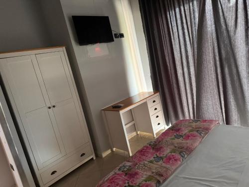 a bedroom with a bed and a cabinet and a tv at Hotel VistaMare in Pozzuoli