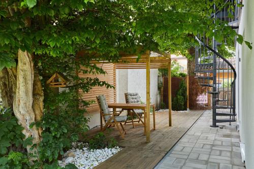 a patio with a table and chairs under a pergola at Ferienwohnung zum Hochgarten in Krün