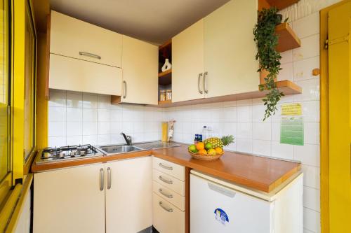 a kitchen with white cabinets and a bowl of fruit at Club del Sole Adriano Family Collection in Punta Marina