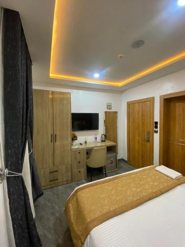 a hotel room with a bed and a desk at Lighthouse Inn and suites in Ibadan