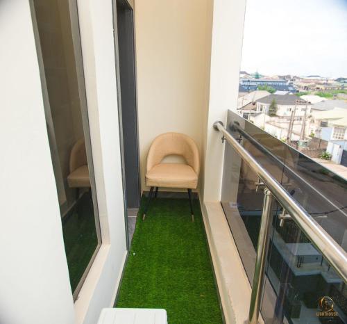 a balcony with a chair and green grass at Lighthouse Inn and suites in Ibadan