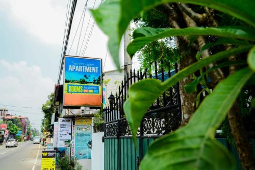 a building with a sign on the side of a street at Samanmali Apartment in Unawatuna