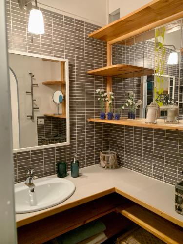 une salle de bain avec un lavabo et un miroir dans l'établissement 3 étoiles au bord de l'eau, à La Seyne-sur-Mer