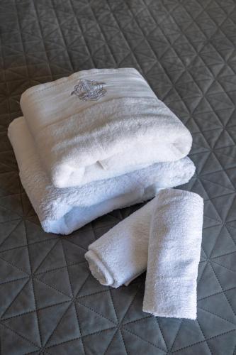 two white towels sitting on top of a bed at Glyfada center seaview B in Athens