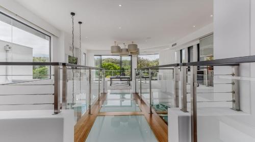 a glass corridor in a house with a glass floor at Sandcastles in Casuarina