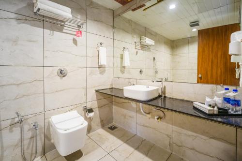 a bathroom with a toilet and a sink at RiverView Tent Resort in Kevadia