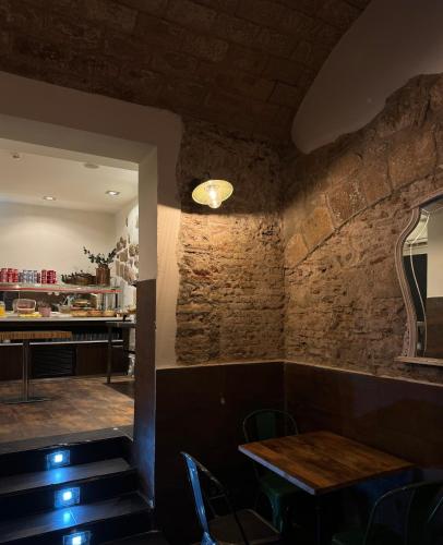 a dining room with a table and a brick wall at Hostal Fernando in Barcelona
